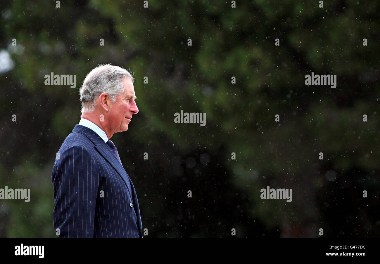 Der Prinz von Wales steht im Regen während eines Besuchs der Portugal Naval School in Lissabon, Portugal. Stockfoto