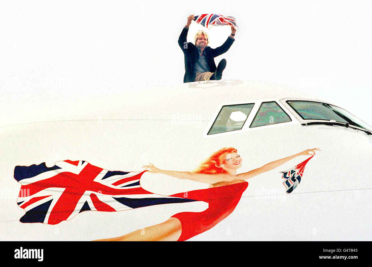 Jungfrau-Vorsitzende Richard Branson stellt für die Medien bei einem Fototermin am Flughafen Heathrow heute (Donnerstag). Virgin Atlantic heute (Donnerstag) hob die Fahne Gedroppt von British Airways und und gliederte sie in sein Logo Scarlet Lady. BA nahm im vergangenen Monat die Anschluß-Markierungsfahne der Leitwerke seiner Flugzeuge außer Concorde ab und ersetzte sie durch eine Reihe von weltweiten Gemälde. Foto von Tim Ockenden/PA. PA-Geschichte-AIR-Flagge zu sehen Stockfoto