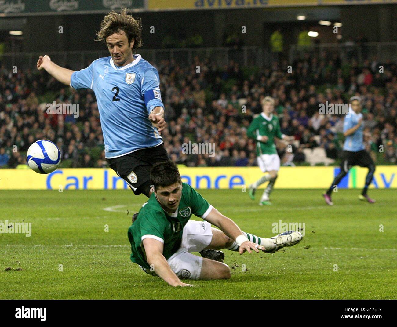 Shane Long der Republik Irland (rechts) geht nach dem Kampf um den Ball mit Diego Lugano aus Uruguay (links) nach unten. Stockfoto
