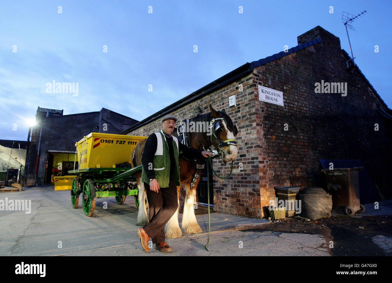 Wynne Hull steht neben Hope the Shire Horse bei Salford Skip Hire