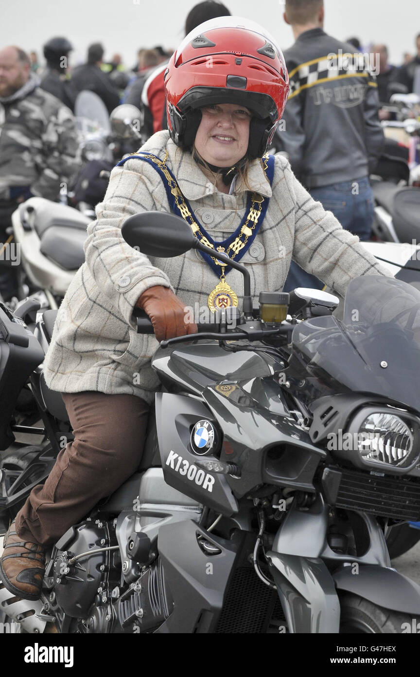 Die Bürgermeisterin von Wootton Bassett, Mary Champion sitzt in der Fahrerposition auf einem Motorrad, wo sie Pillion durch ihre Stadt reiten wird, Als Motorradfahrer versammeln sich auf dem Flugplatz Hullavington in Vorbereitung auf die "Ride for Respect" Charity-Fahrt durch die Wiltshire-Stadt Wootton Bassett zu Hilfe von Afghan Heroes. Stockfoto