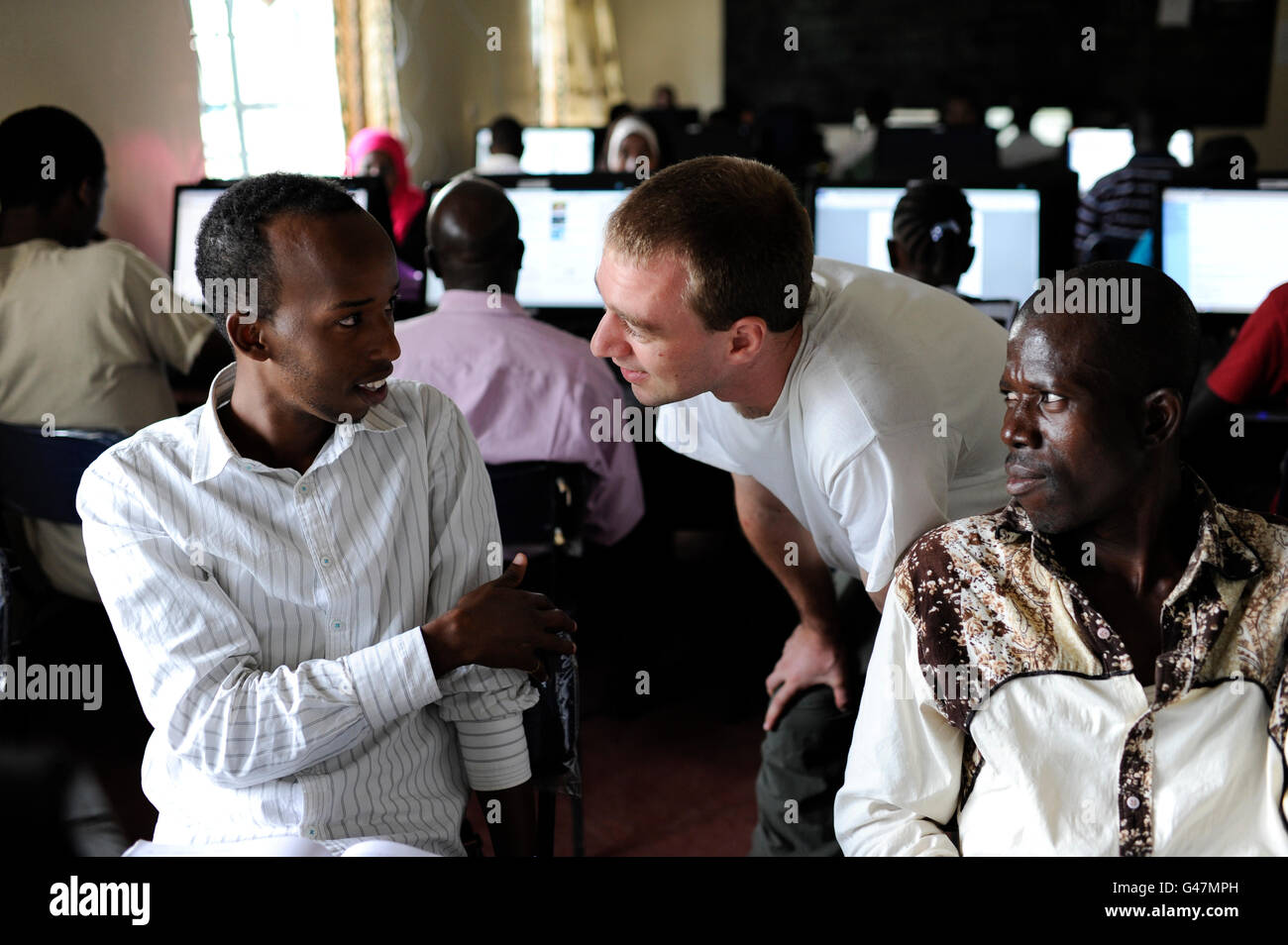 KENYA Turkana Region, Flüchtlingslager Kakuma, JRS Jesuit Refugee Service, Computerschulung für Flüchtlinge, E-Learning oder Fernstudium an der Universität, Helfer im Gespräch mit Studenten, digital, Digitalisierung Stockfoto