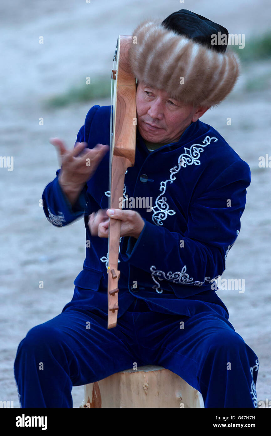 Kirgisische Musiker spielt die lokale Intrument Komuz. Stockfoto