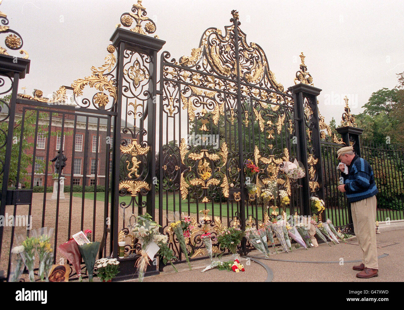 Ein Mann steht still, während er die Blumenbeute vor den Toren des Kensington Palace - der offiziellen Residenz von Diana, Prinzessin von Wales - heute Morgen (Sonntag) beobachtet. Stockfoto