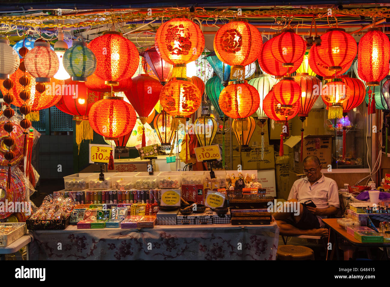 Singapur, Singapur - 12. Dezember 2014: Eine Straße Verkäufer in Chinatown wacht über sein Geschäft mit Lampions. Stockfoto