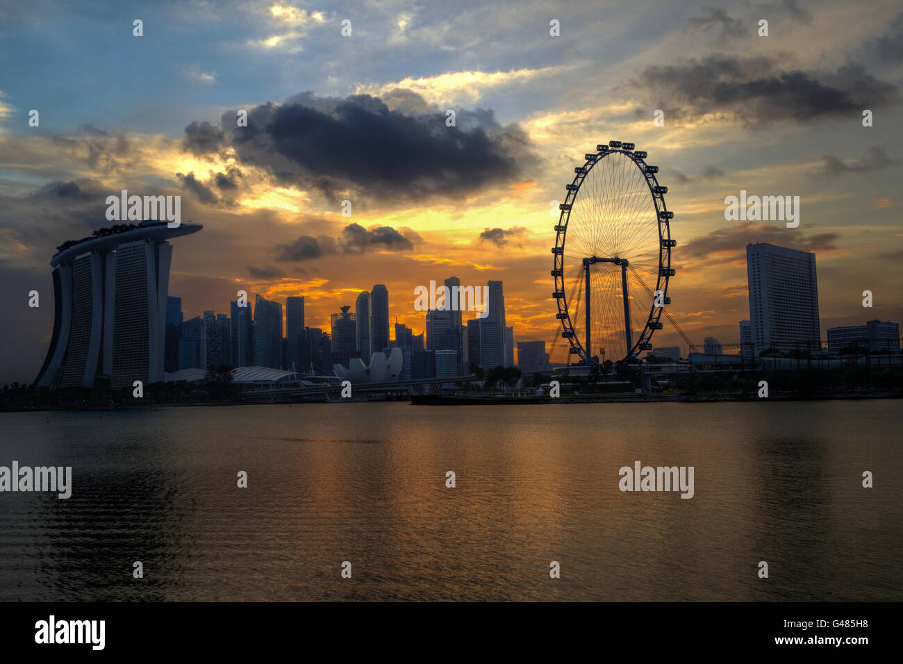 Ein Goldener Sonnenuntergang über Singapurs Skyline schafft eine interessante Silhouette der Marina Bay. Stockfoto