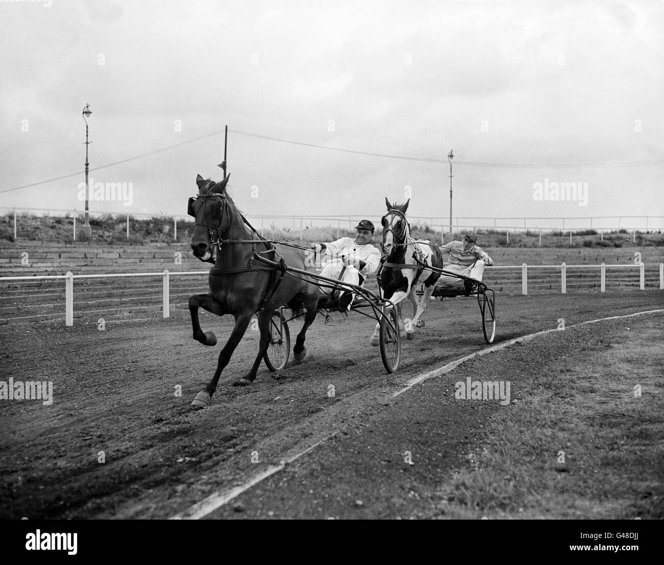 „Sadie“, geritten von Jockey Fred Moore, führt „Dans Boy“, geritten von Reg Prescott, in einem Testlauf an. Stockfoto