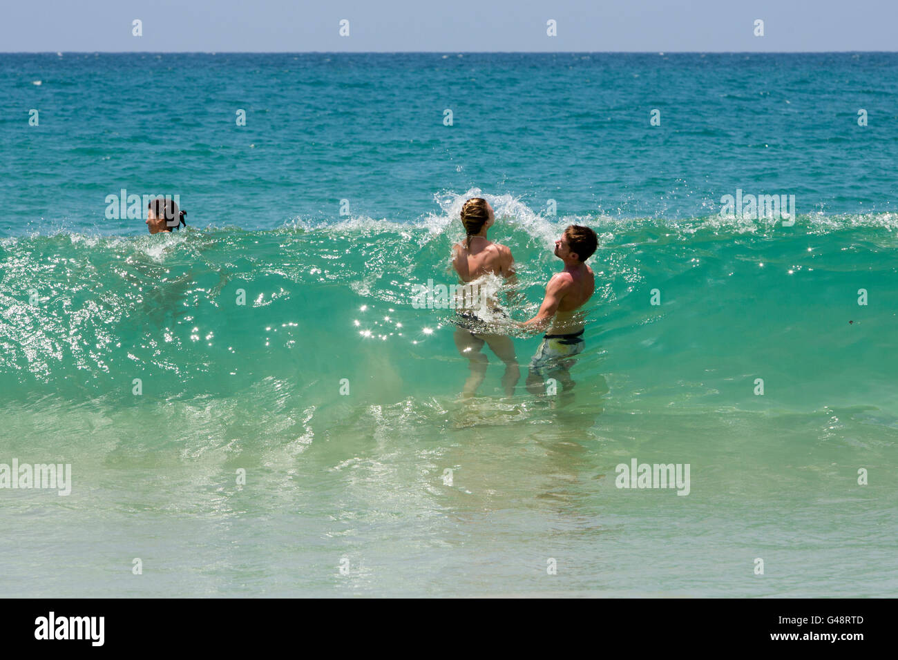 Sri Lanka, Mirissa Beach, große Kopfhöhe Welle schlagen Paar im Meer Stockfoto