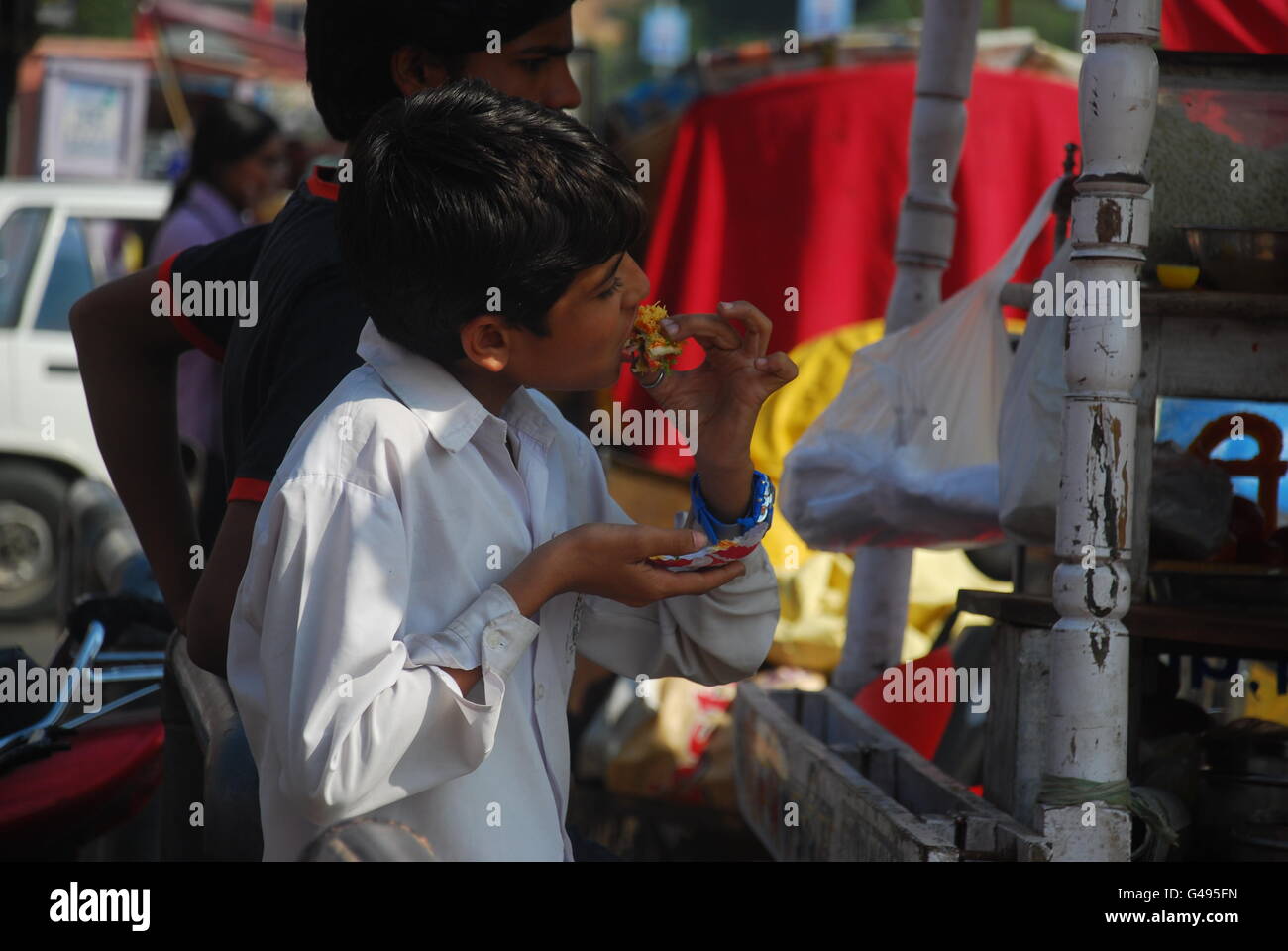 Junge essen indische Süßigkeiten, Straße Garküche, Jaipur, Rajasthan, Indien Stockfoto