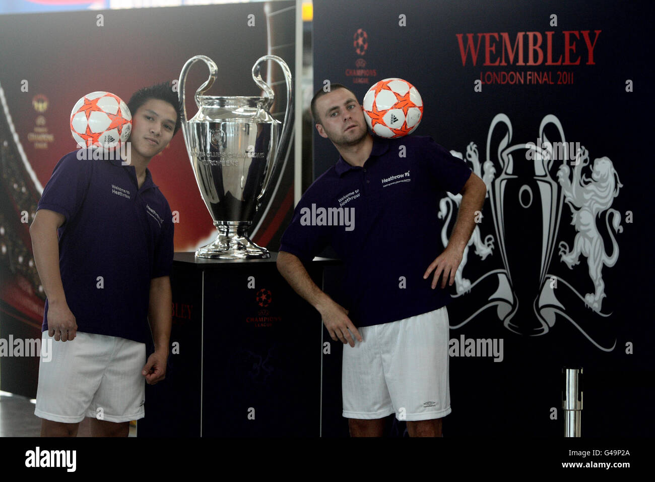 Die Freestyle-Fußballer Francis Vu (links) und Noel Battle demonstrieren ihr Können im Terminal 5 des Flughafens Heathrow, während die UEFA Champions League-Trophäen vor dem Herrenfinale in Wembley am 28. Mai 2011 und dem Damenfinale in Craven Cottage am 26. Mai 2011 ausgestellt werden. Stockfoto