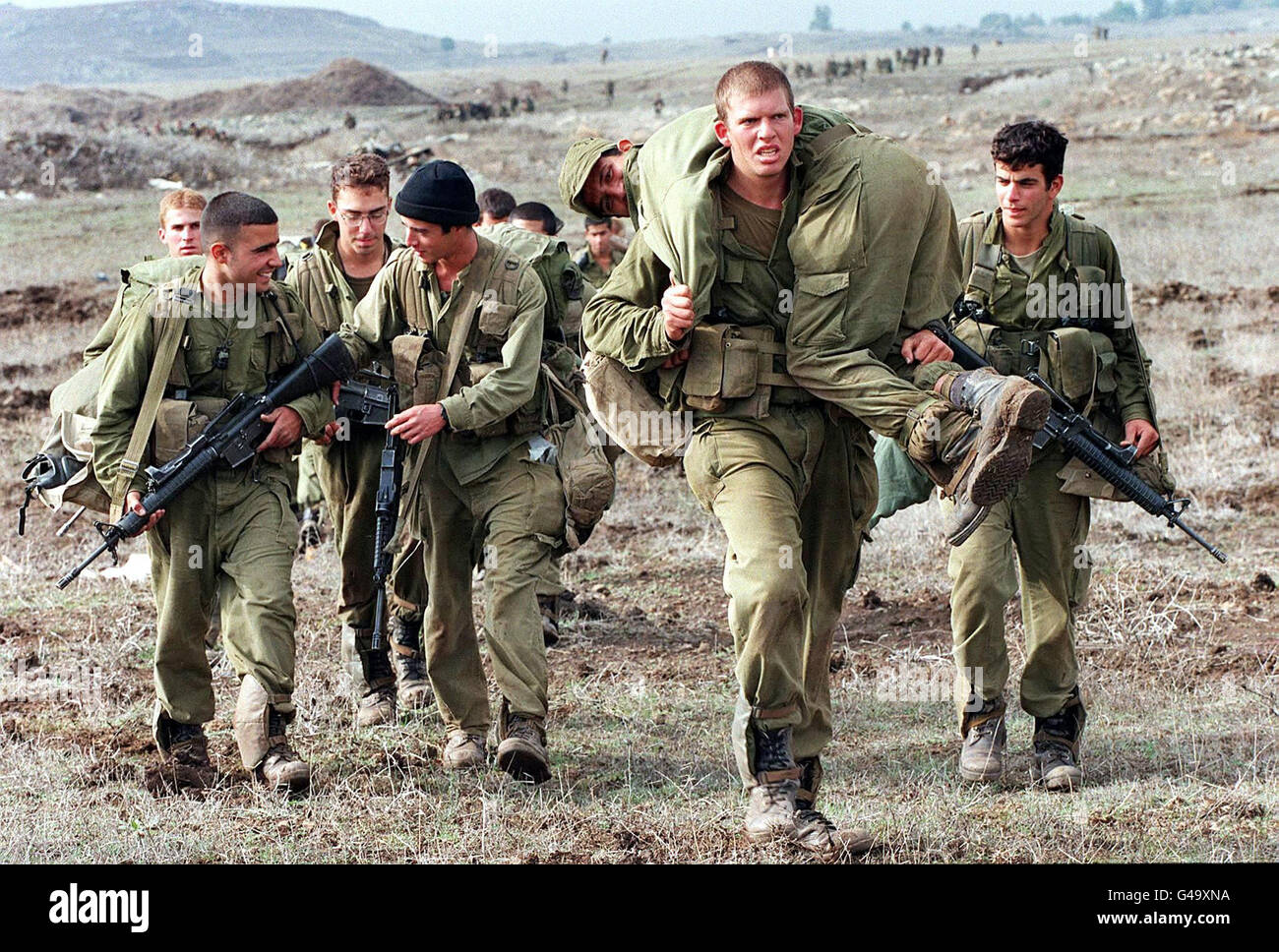 Am letzten Tag der Trainingsmanöver der Givaati-Brigade, dem 06. November 1997, führt eine Gruppe israelischer Soldaten einen schlammigen Hügel hinauf, der einen „verwundeten“ Soldaten auf den Golanhöhen trägt. Syrien sagte diese Woche, dass es in drei Monaten einen Friedensvertrag mit Israel erreichen könnte, wenn Israel zustimmte, den 1967 besetzten und später annektierten Golan zurückzugeben. Die Friedensverhandlungen zwischen Israel und Syrien wurden seit über einem Jahr ausgesetzt. Stockfoto