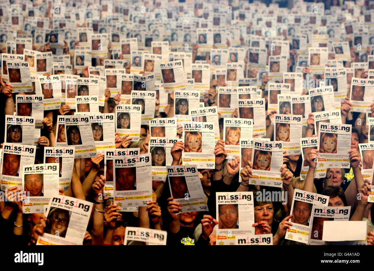 Rund 10,000 Mitglieder des Rock Choir halten Plakate mit Bildern vermisster Kinder in der Wembley Arena im Norden Londons hoch, während einer Fotoaktion, die von der Miles for Missing People Charity organisiert wurde, um den Internationalen Tag der vermissten Kinder 2011 am 25. Mai zu markieren. Stockfoto