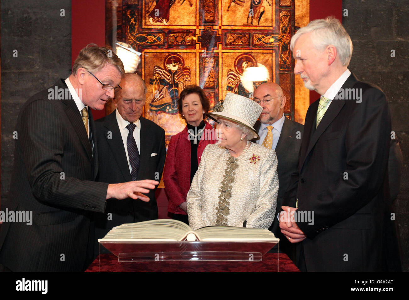 Königin Elizabeth II. Und der Herzog von Edinburgh betrachten ein Faksimile des Buches Kells mit dem Provost des Trinity College Dublin Dr. John Hegarty, Bibliothekar Robin Adams und Kanzlerin der Universität Dr. Mary Robinson während des ersten Tages ihres Staatsbesuchs in Irland. Stockfoto