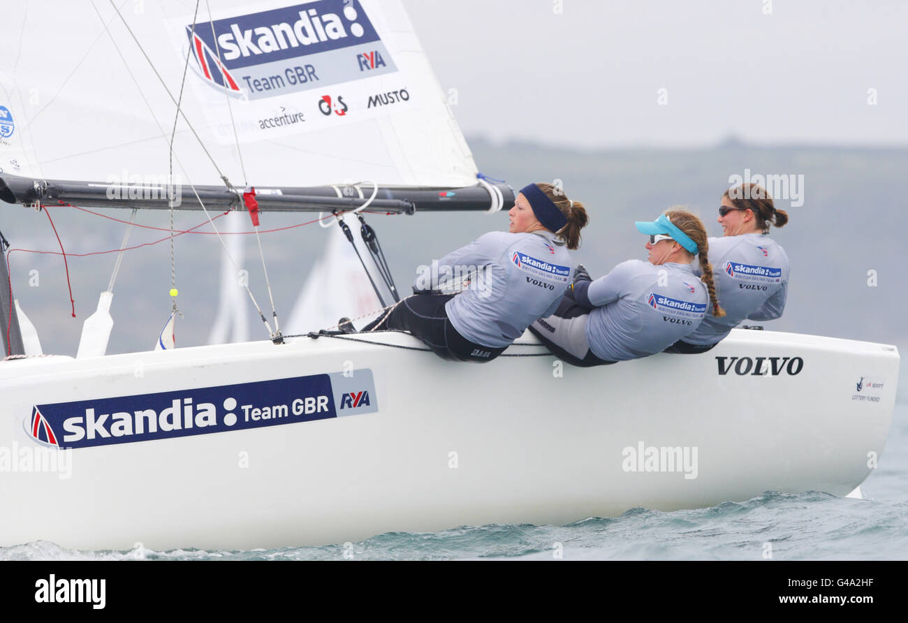 Mitglieder des britischen olympischen Segelteams beim Match Racing Event (von links nach rechts) Kate Macgregor, Annie Lush und Lucy Macgregor an der Weymouth and Portland National Sailing Academy, dem Segelort der Olympischen Spiele 2012 in London. Stockfoto