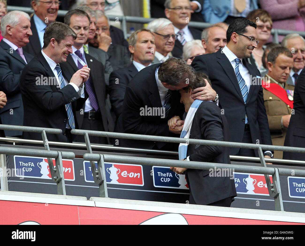 Roberto Mancini (rechts), Manager von Manchester City, wird vom Chief gratuliert Geschäftsführer Garry Cook (Mitte) und Brian Marwood, Verwaltungsbeamter des Fußballs (Links) nach dem Gewinn des FA Cup Stockfoto