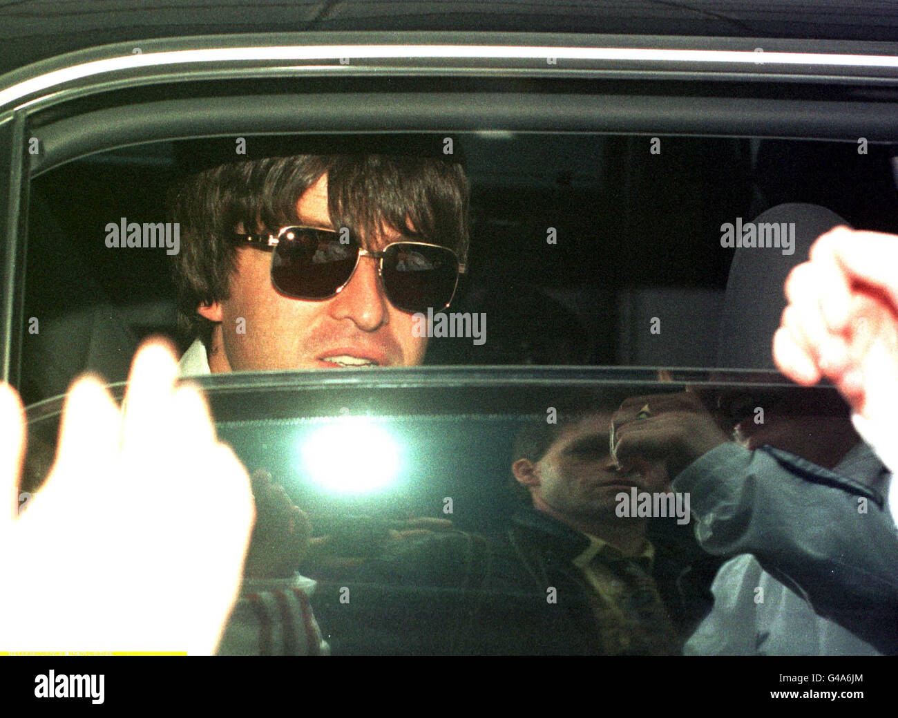 Noel Gallagher von Oasis guckt über ein halb geöffnetes Fenster, als er heute (Freitag) in einer abgedunkelten Limousine vom Flughafen Gatwick weggefahren wird, nachdem die Band aus Mexiko hereingeflogen ist, wo sie ihre weltweite Tour abgeschlossen hat. Siehe PA Story SHOWBIZ Oasis. Foto von Adam Butler Stockfoto