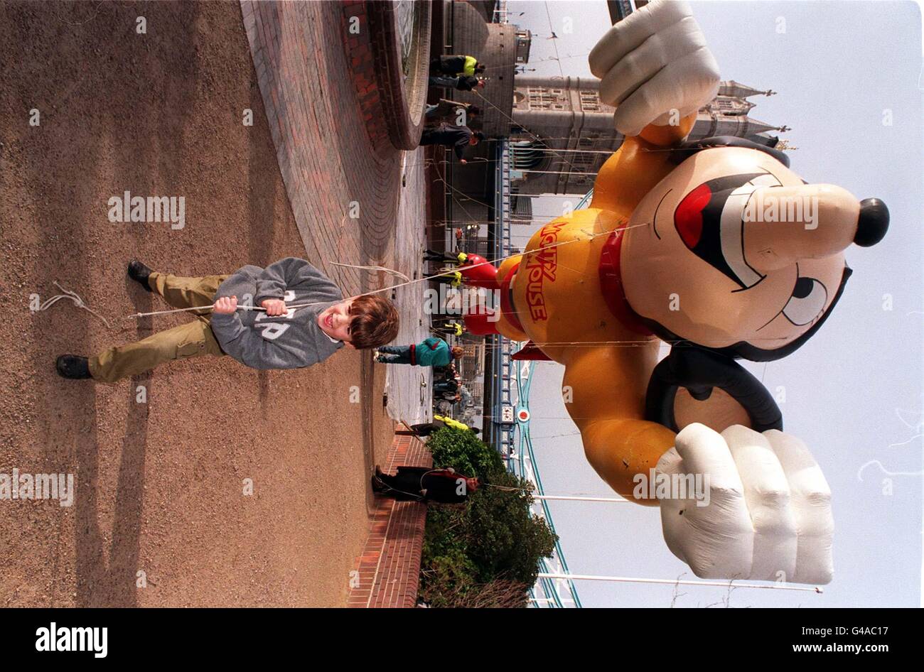 Der junge Lachlan Murphy (4) kämpft heute Morgen (Sonntag) darum, einen riesigen Schlauchboot der Zeichentrickfigur "Mighty Mouse" zu halten, während sie über dem Zentrum Londons thront. Das riesige Nagetier wurde vor der Tower Bridge vor Gericht gestellt, um sich auf die London Parade vorzubereiten, die am Neujahrstag in der Hauptstadt stattfinden wird. Es wird erwartet, dass mehr als eine Million Menschen Mighty und seine Mitcharakter in der größten Parade sehen werden, die jemals in Großbritannien abgehalten wurde. Foto von Neil Munns/PA Stockfoto