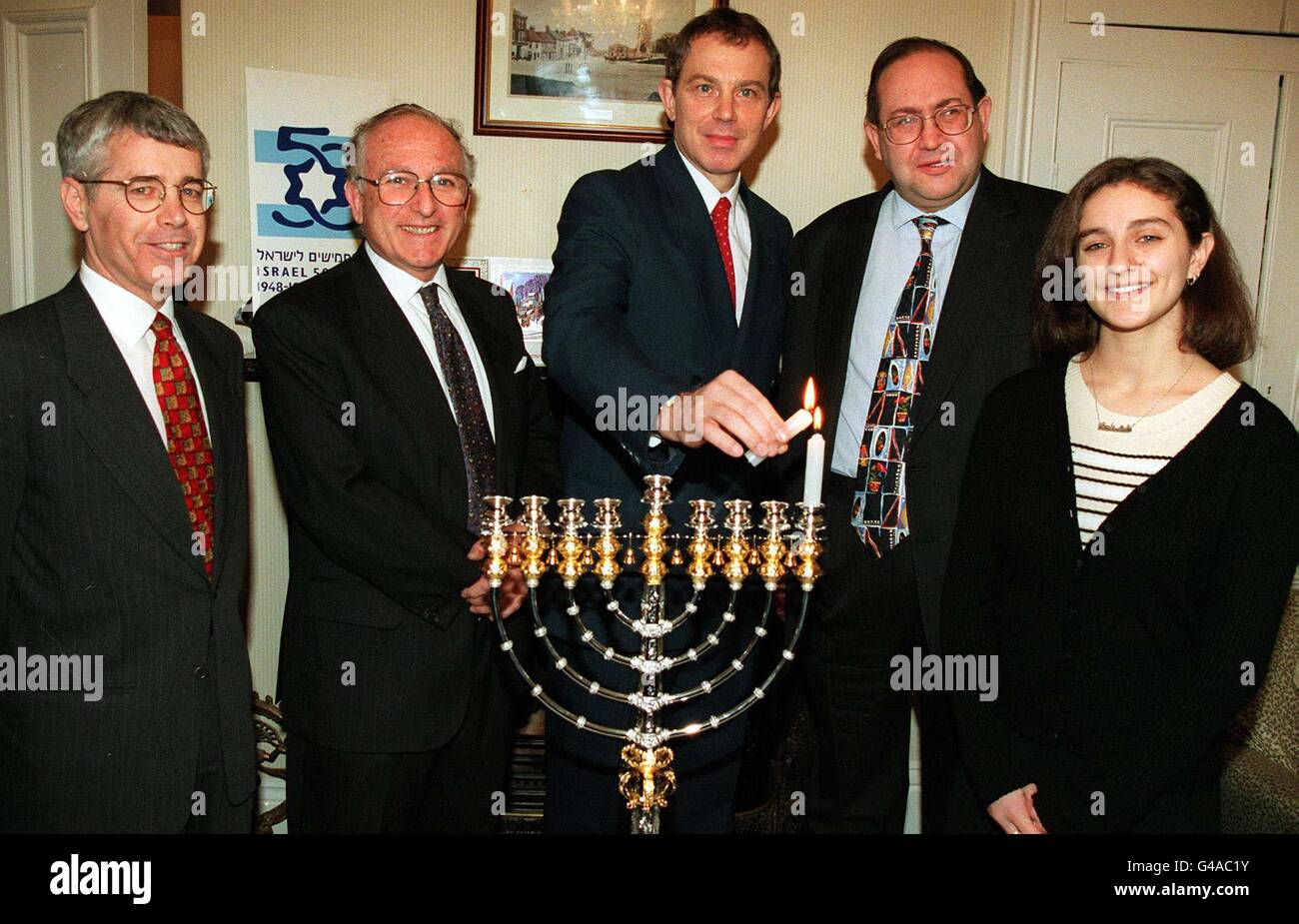 Premierminister Tony Blair wurde heute (Dienstag) von Führern der jüdischen Gemeinde in seinem Haus in der Kolonie Trimdon begleitet, um die erste Hannukah-Kerze anzuzünden, die den 50. Jahrestag Israels feiert und den ersten Tag des alten jüdischen Festivals anführt. L-R Amiram Maggid -amtierender Botschafter Israels, Lord Janner, Tony Blair, Eldred Tabachuk QC -Präsident des Board of Deputies of British Jews und Marissa Sakol- Union of Jewish Students. FOTO OWEN HUMPHREYS/PA*POOLBILD* Stockfoto