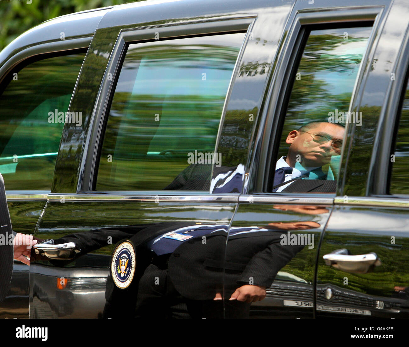 Ein Geheimagent hält im Winfield House, dem offiziellen Wohnsitz des US-Botschafters, im Regent's Park im Zentrum von London die Tür des Autos von US-Präsident Barack Obama, bekannt als "das Tier". Stockfoto