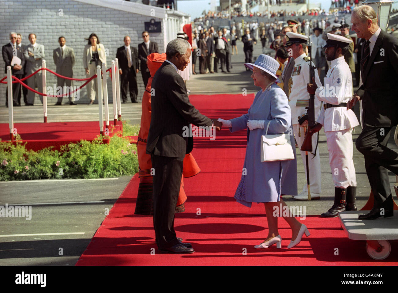 Südafrikas Präsident Nelson Mandela begrüßt Königin Elizabeth II., als sie zum offiziellen Start ihres ersten Besuchs seit 1947 von der königlichen Yacht Britannia in Kapstadt aus kommt Stockfoto