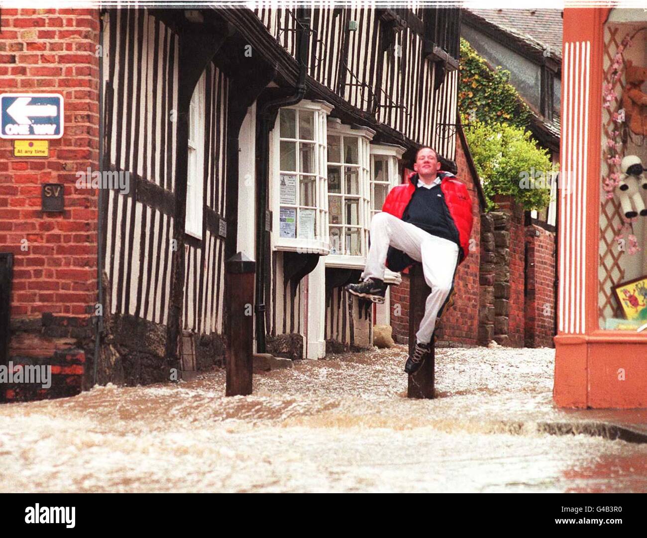 Heute Morgen (Freitag) flüchtet ein Mann vorübergehend auf einer Säule in Ledbury, Hereford und Worcestershire, nachdem es über Nacht stark geregnet hatte, was zu ausgedehnten Überschwemmungen führte. PA-Fotos. Siehe PA Geschichte WETTER Ostern Stockfoto