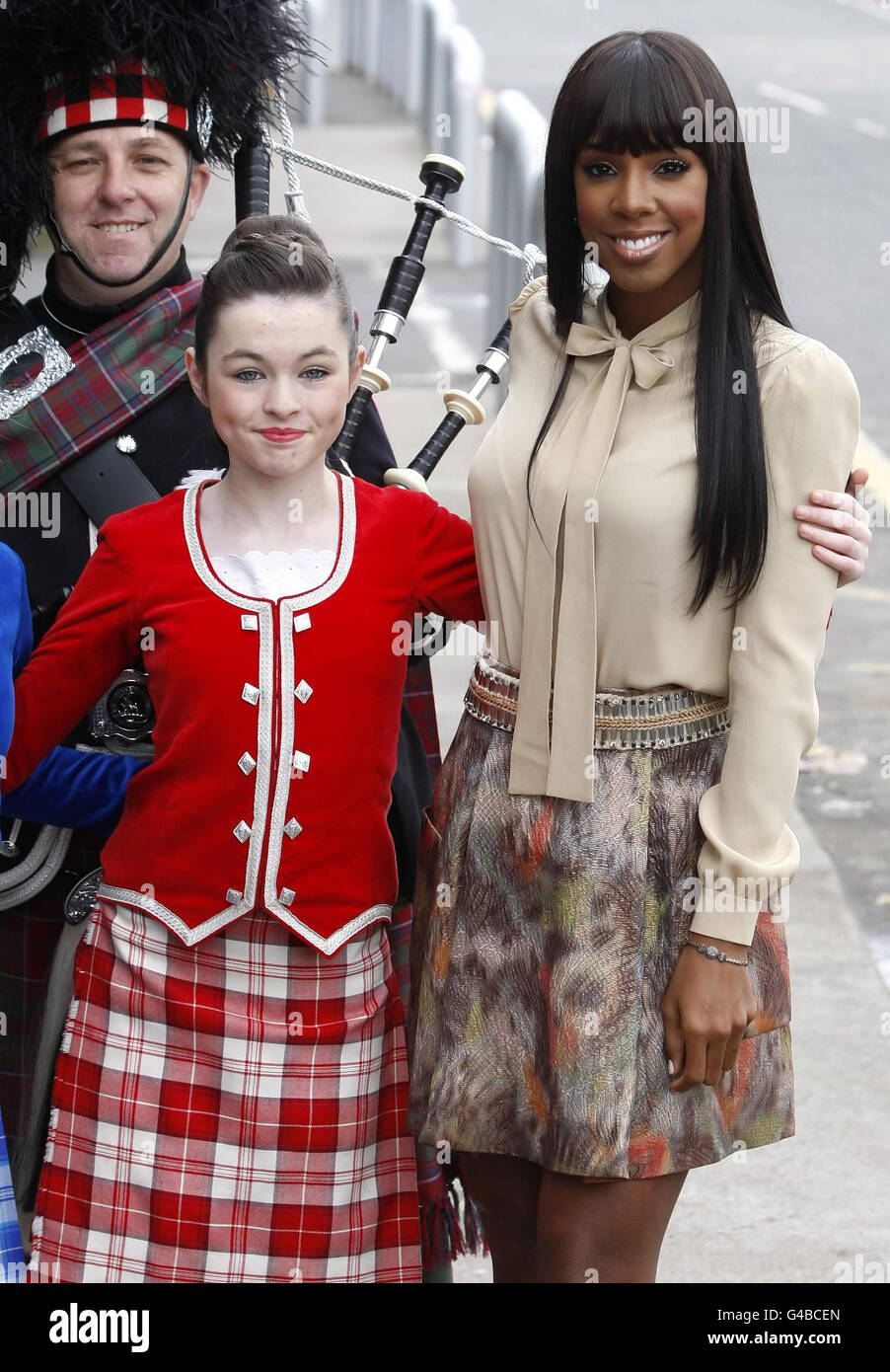 Richterin Kelly Rowland mit der schottischen Tänzerin Caragh MacKinnon und Piper Iain Grant kommt sie vor den X Factor Auditions in der Stadt am SECC in Glasgow, Schottland an. Stockfoto