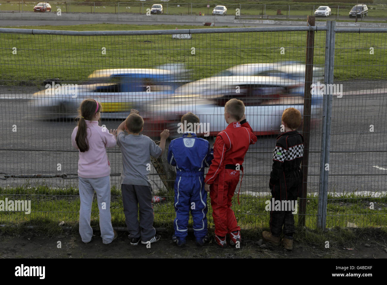 Eine Gruppe von Kindern beobachtet das Stockcar-Rennen im Nutts Corner Oval in Crumlin Nordirland. Bilddatum: Samstag, 11. Juni 2011 . Das Foto sollte lauten: Niall Carson/PA Wire Stockfoto