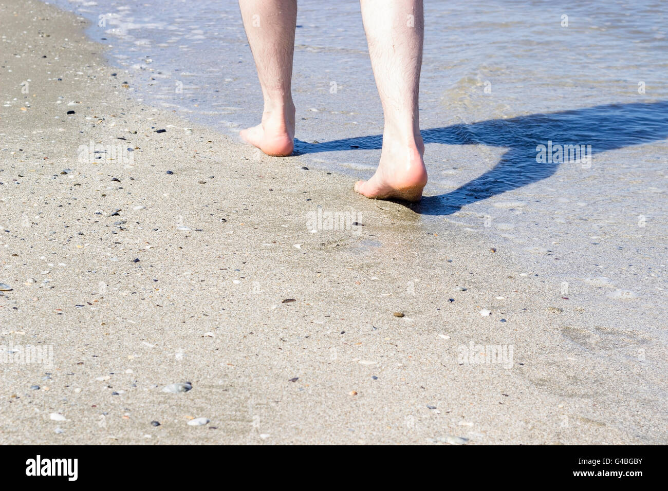 Einzigen Mann zu Fuß am Strand. Stockfoto