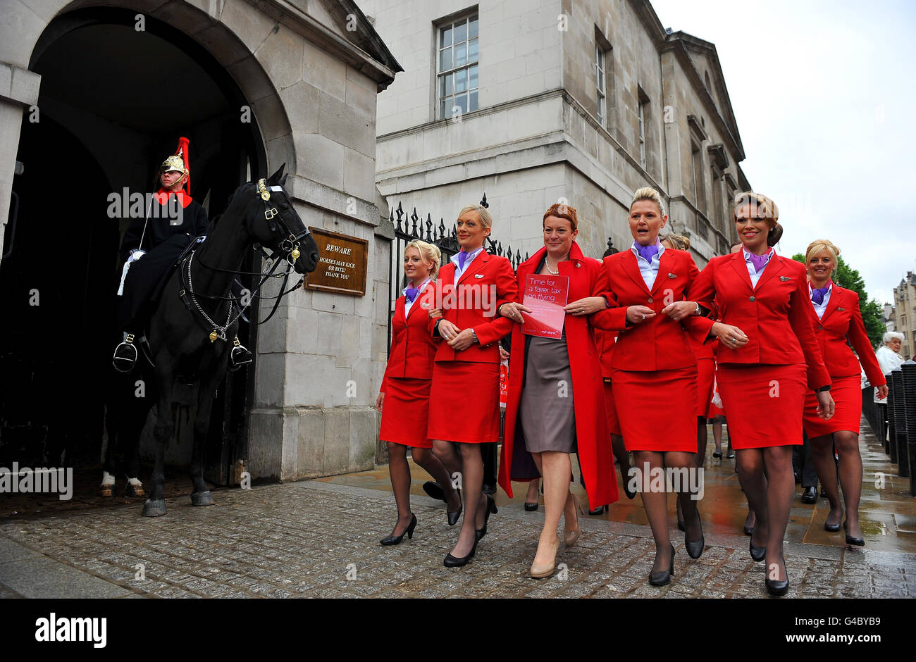 Julie Southern, Chief Commercial Officer von Virgin Atlantic (Mitte), wird von Kabinenbesatzungen begleitet, die Whitehall, London, zum Finanzministerium hinunterlaufen, wo sie sowohl die Vorlage über Air Passenger Duty (APD) als auch Tausende von Postkarten, die in einer Passagierbefragung gesammelt wurden, übergaben. Zum Abschluss des Konsultationszeitraums der Regierung zu APD. Stockfoto