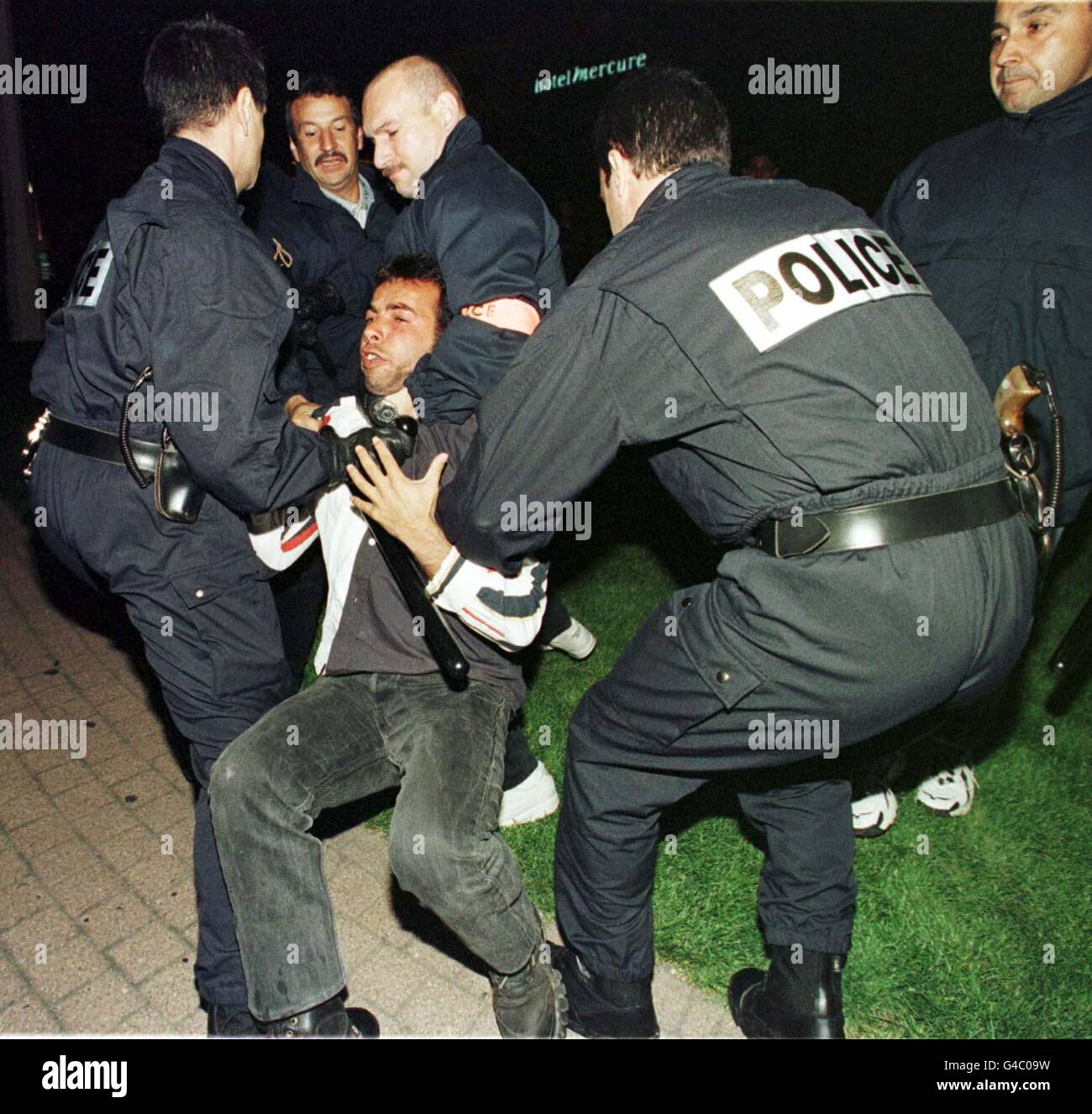 Französische Polizisten halten einen Fußballfan zurück, nachdem gestern Abend (Samstag, 13. Juni) unter den Anhängern vor der Bar Olympique Marseille im Vieux Port der Stadt Unruhe aufkam. Die Gegend wurde am Wochenende von tausenden englischen Fans überschwemmt, als sie am morgigen Nachmittag (15. Juni) in der Stadt die englische Mannschaft bei ihrem Eröffnungsspiel gegen Tunesien unterstützen. EDI Foto von Peter Jordan/PA Stockfoto