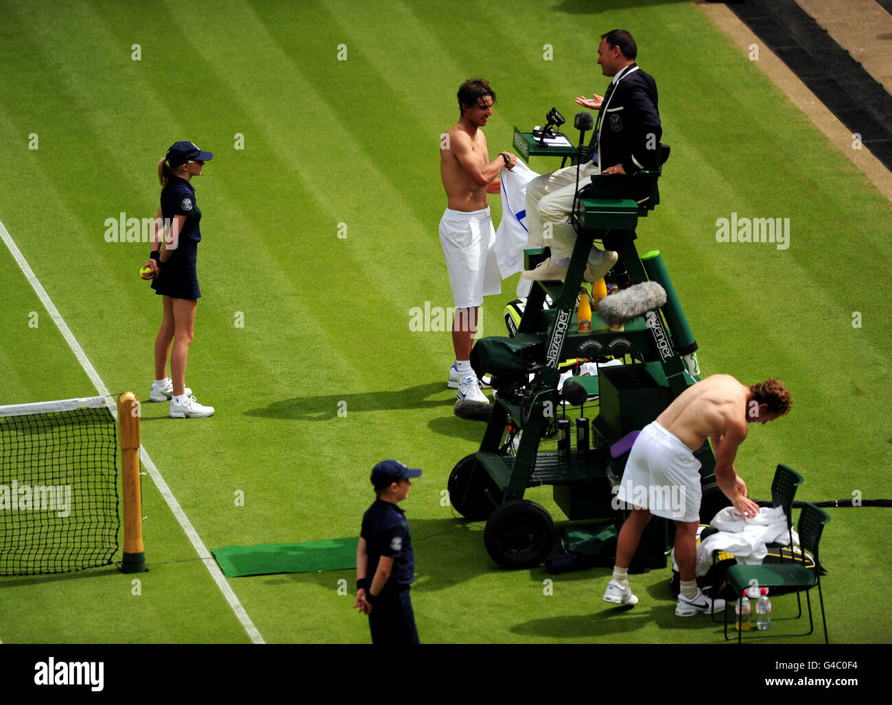 Der Spanier Rafael Nadal und der US-Amerikaner Michael Russell wechseln am Tag eines der Wimbledon Championships 2011 beim all England Lawn Tennis and Croquet Club, Wimbledon, das Trikot. Stockfoto