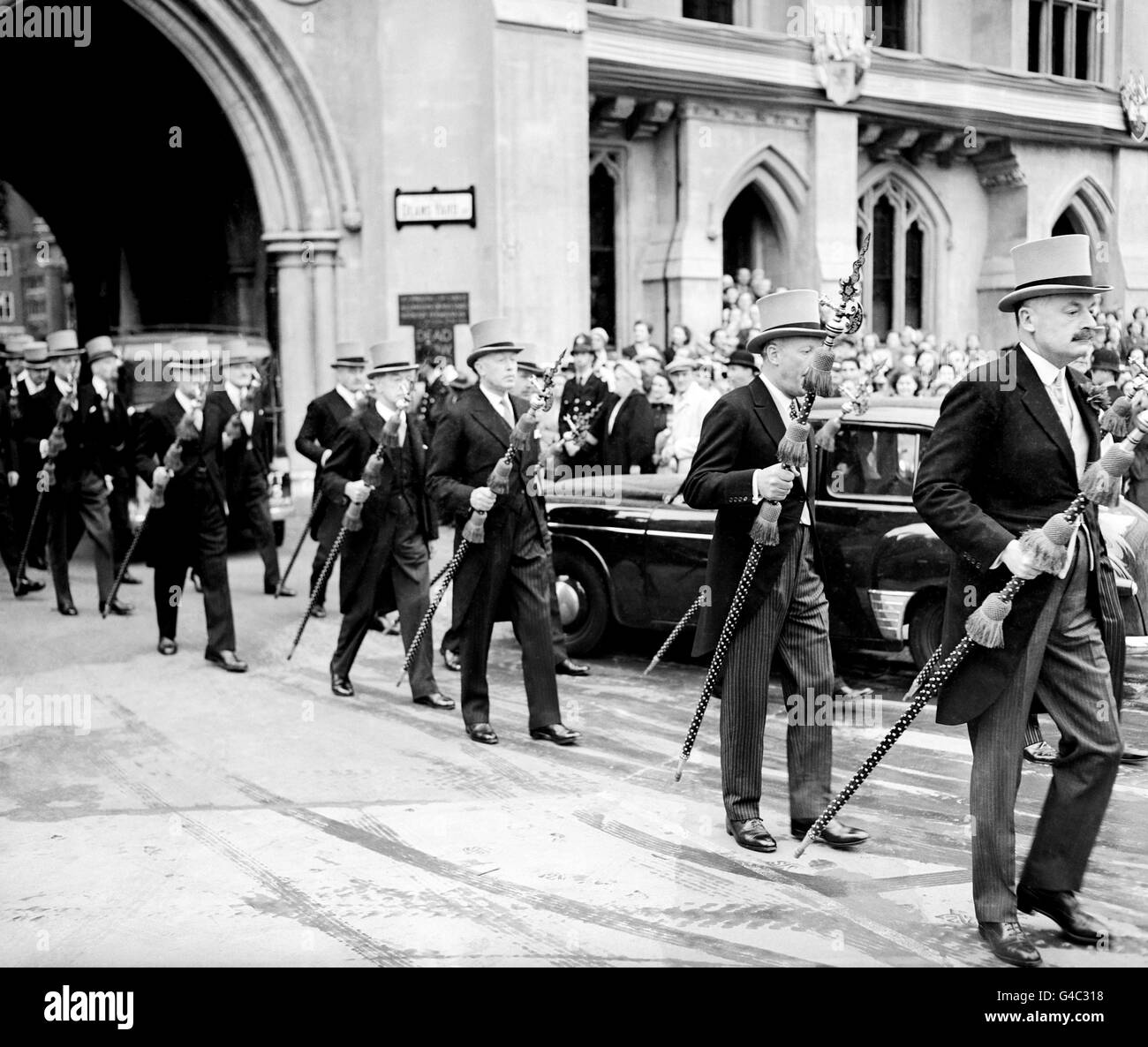 Mitglieder des ehrenwerten Korps der Herren am Arm tragen ihre hochdekorativen Poleaxes, während sie zur Westminster Abbey für eine Krönungsprobe gehen. Stockfoto