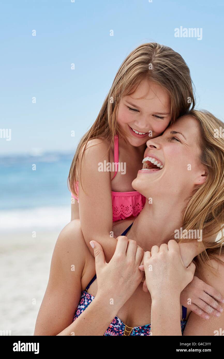 -MODELL VERÖFFENTLICHT. Mutter und Tochter am Strand lachen. Stockfoto