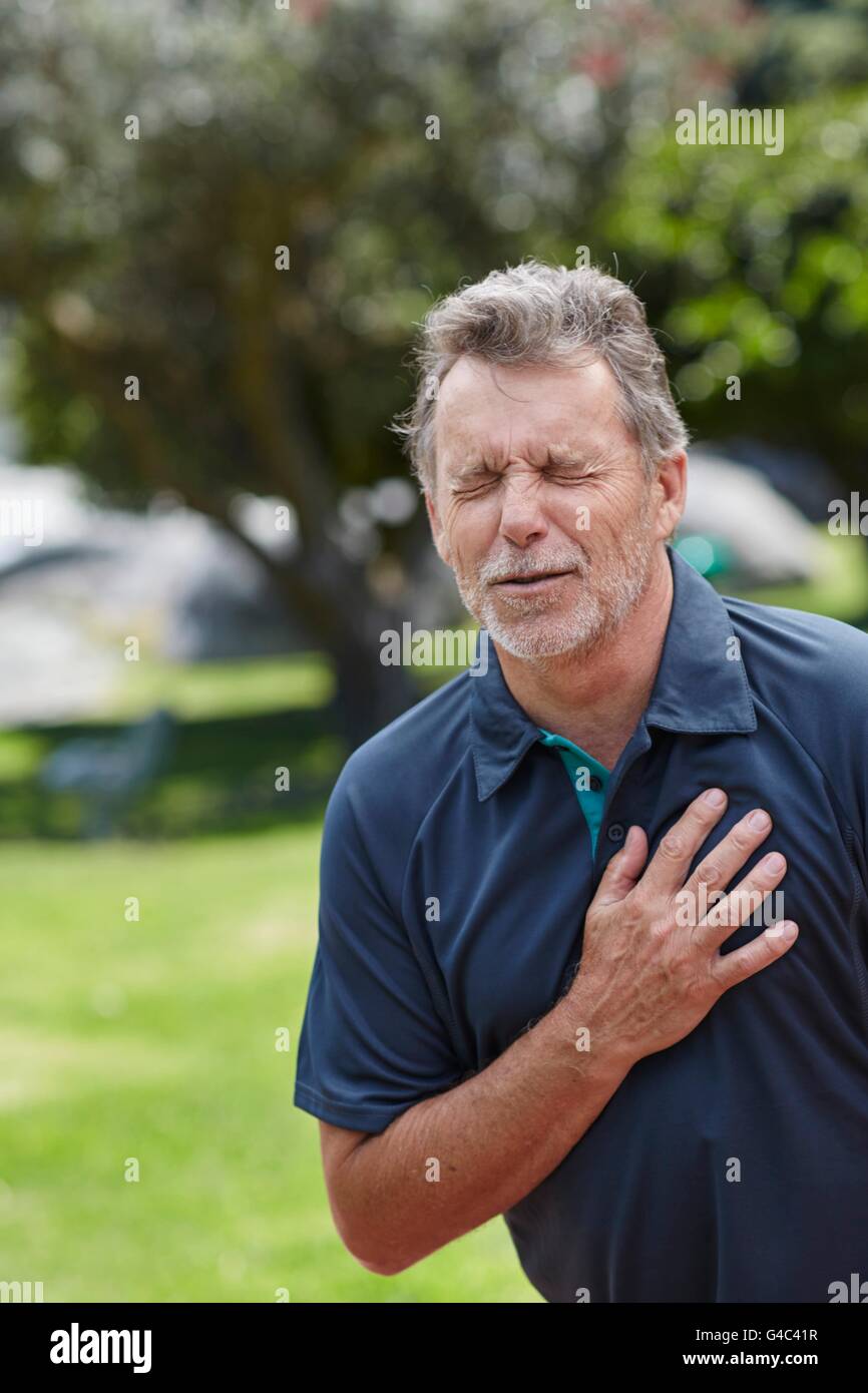 -MODELL VERÖFFENTLICHT. Ältere Mann, der seine Brust Schmerzen hält. Stockfoto