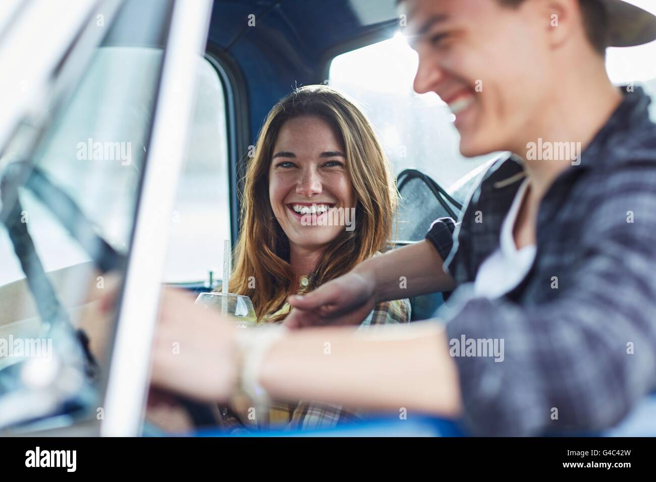 -MODELL VERÖFFENTLICHT. Junges Paar in einem Auto, lachen. Stockfoto