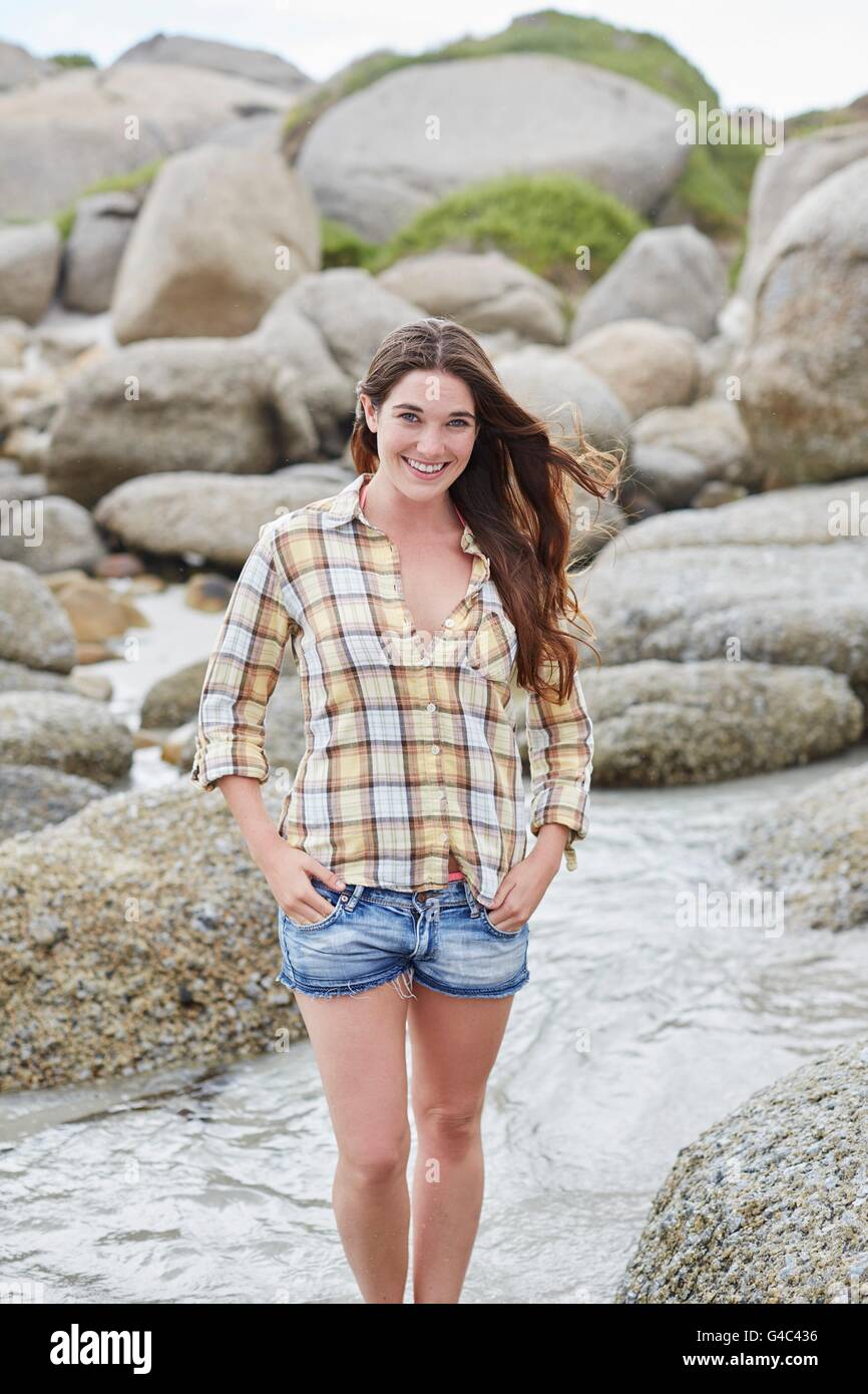 -MODELL VERÖFFENTLICHT. Junge Frau am Strand, lächelnd. Stockfoto