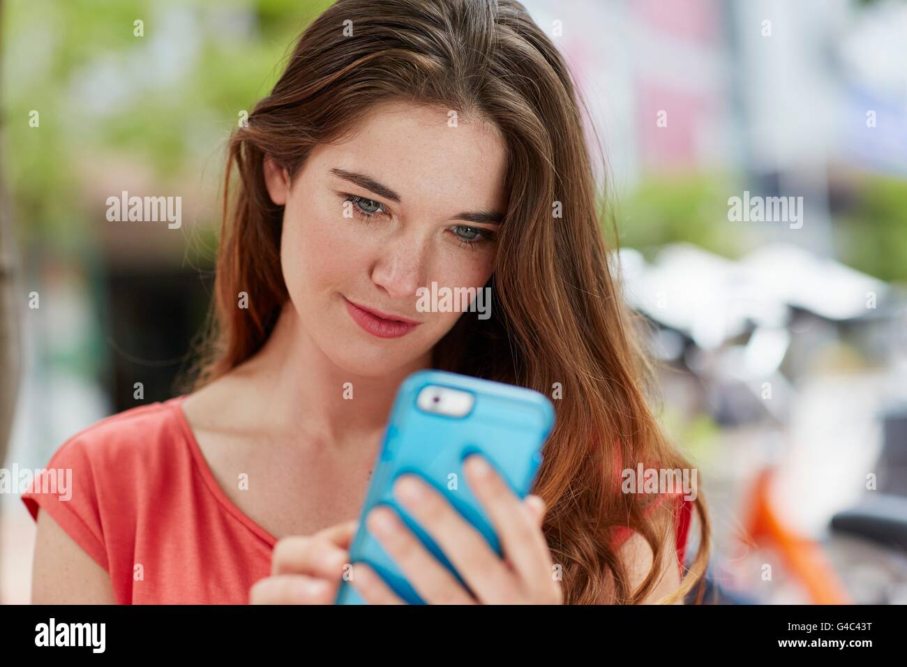 -MODELL VERÖFFENTLICHT. Junge Frau mit Smartphone. Stockfoto