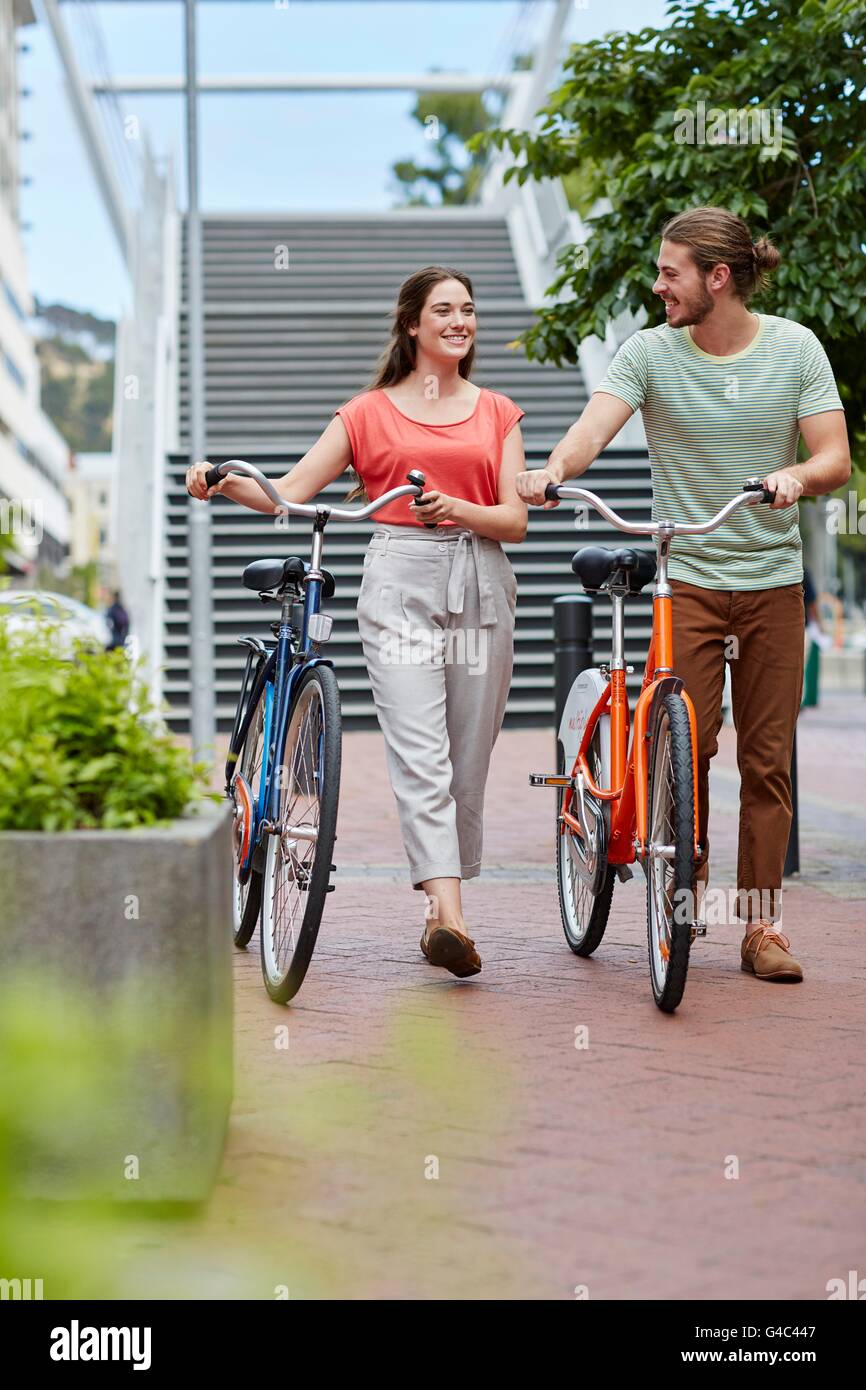 -MODELL VERÖFFENTLICHT. Junge Paare, die mit Fahrrädern. Stockfoto