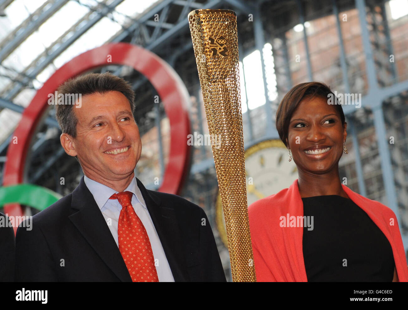 Lord Coe, Vorsitzender von London 2012, und die ehemalige Olympiasiegerin Denise Lewis starten die olympische Flamme, die neue goldene Fackel, die von den 8,000 Läufern auf der Londoner Fackelstaffel 2012 getragen wird. Am Bahnhof St. Pancras in London. Stockfoto