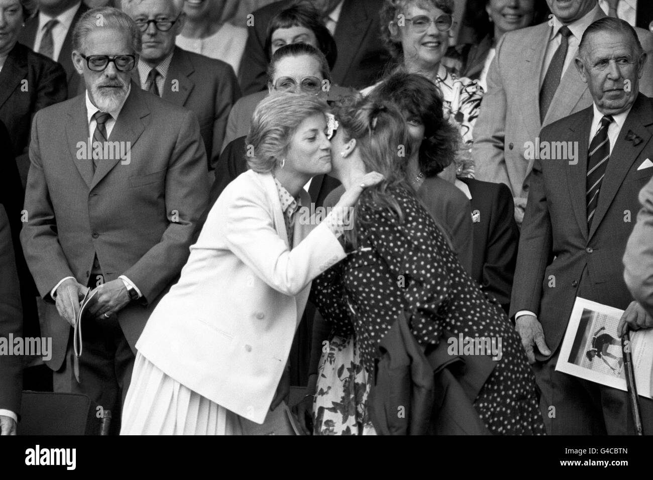 Diana Prinzessin von Wales küsst die Herzogin von York auf die Wange, als sie sich in der Royal Box am Centre Court in Wimbledon treffen. Stockfoto