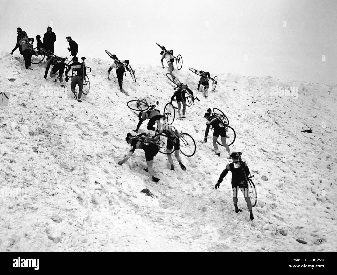 Radfahren - 1963 British National Cycle Cross Championships - Harlow Town Park. Die Teilnehmer kämpfen während des Rennens um die Spitze einer schneebedeckten Steigung. Stockfoto