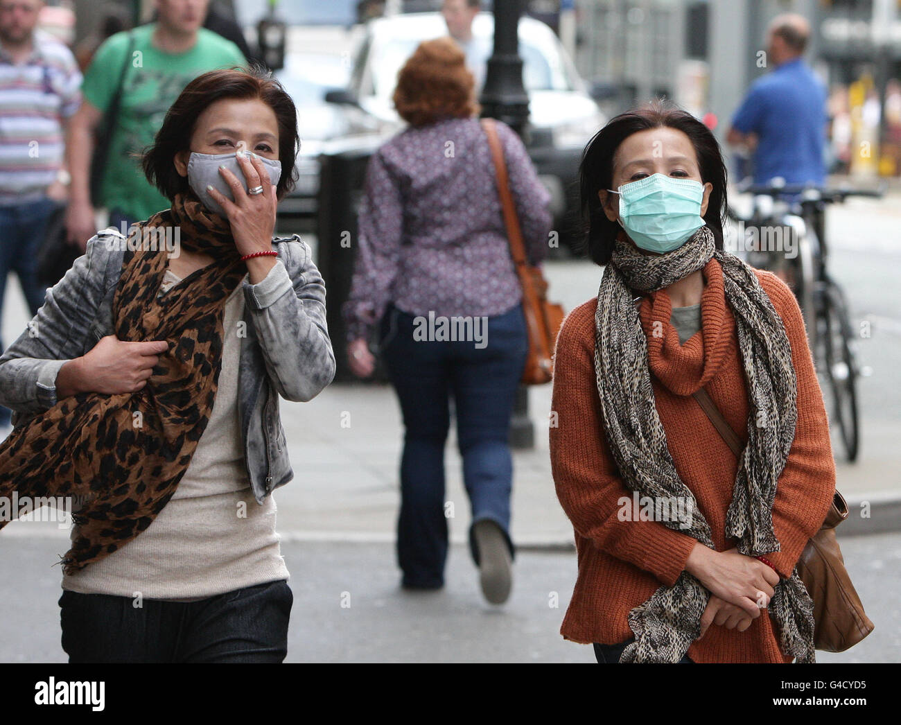 Zwei nicht identifizierte Frauen gehen mit Anti-Verschmutzungsmasken durch das Stadtzentrum von Manchester. Stockfoto