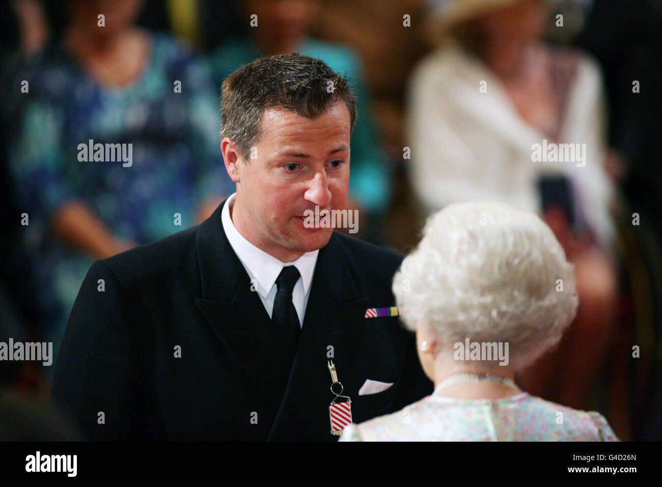 Leutnant Commander Peter Higgins, Royal Navy, wird mit dem Air Force Cross für die Rettungsdienste von 31 Seeleuten aus einem sinkenden Handelsschiff durch Königin Elizabeth II. Im Buckingham Palace, London, dekoriert. Stockfoto