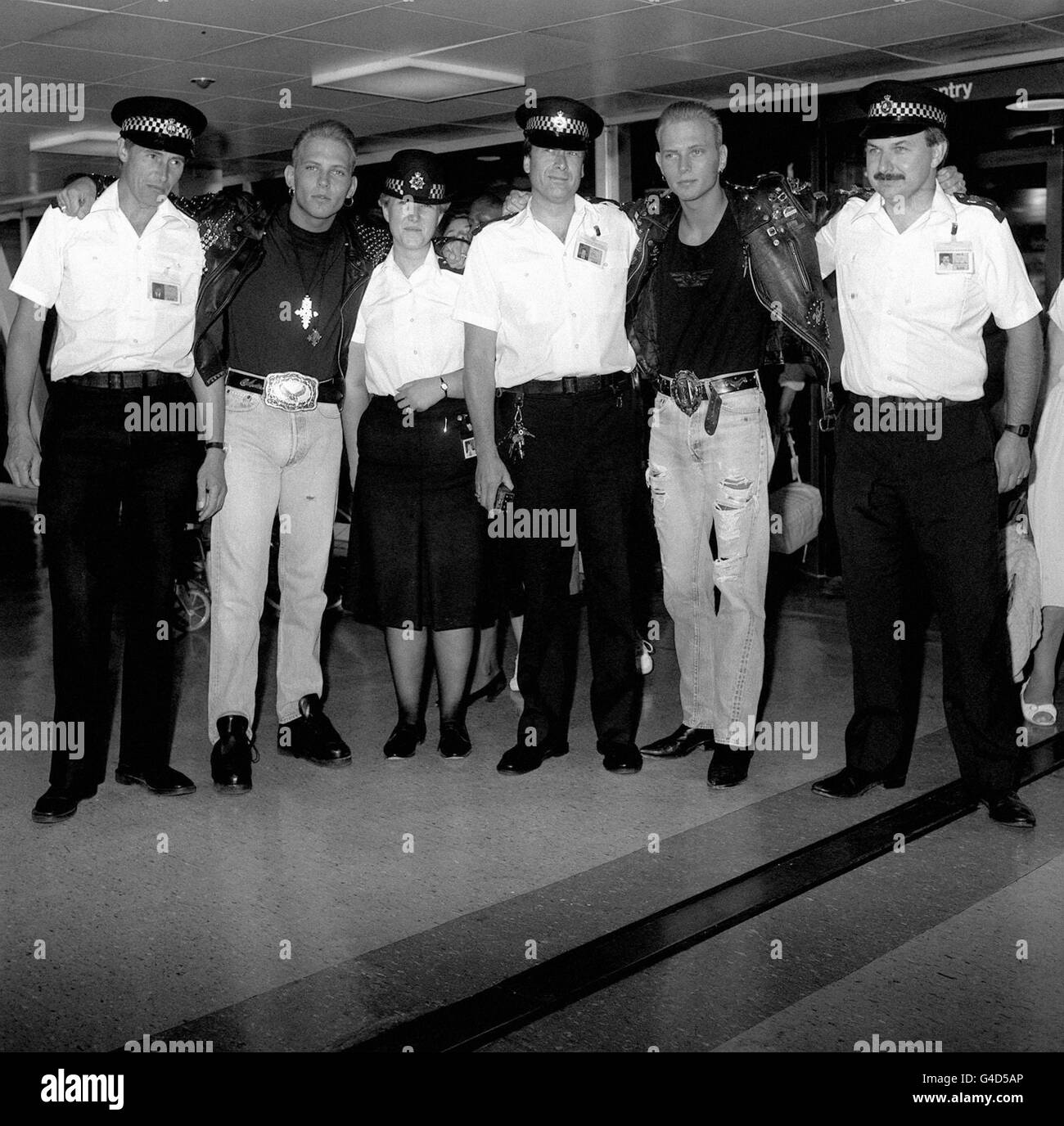 Die Popgruppe „Bros“, die Zwillingsbrüder Matt und Luke Goss, mit der Polizei am Londoner Flughafen Heathrow, bevor sie zum Start ihrer Amerikatour nach Los Angeles fliegen. Stockfoto