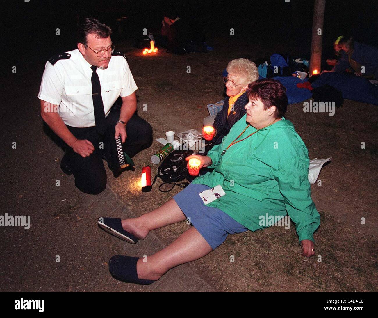 Der Polizist Chris Taylor spricht mit Pamela ward und Carole Ryden (rechts) aus Essex und hält heute (Montag), dem ersten Todestag von Diana, Prinzessin von Wales, eine Kerzenlicht-Mahnwache vor dem kensington Palace ab. Foto von Fiona Hanson/PA Stockfoto