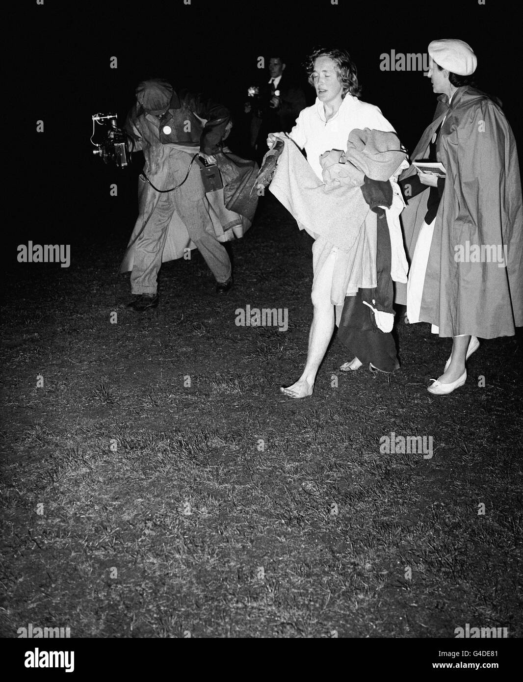 Valerie Ball (London) hält ihre Schuhe, während sie barfuß über das Gras läuft, nachdem sie einen neuen Weltrekord für die 880 Meter aufgestellt hat. Ihre Zeit betrug 2 Minuten 14.5 Sekunden Stockfoto