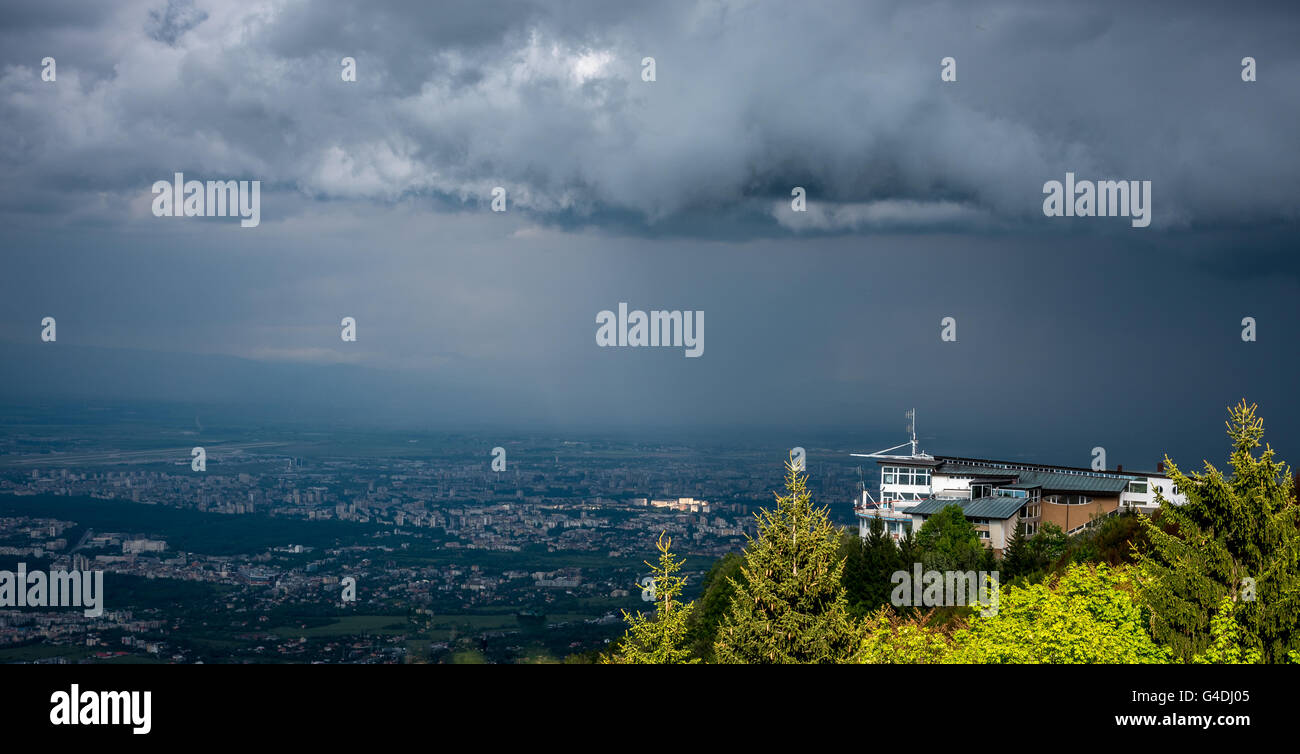 Schweres Gewitterwolken über Sofia, Bulgarien mit einer weißen Hütte auf einem Berggipfel Stockfoto