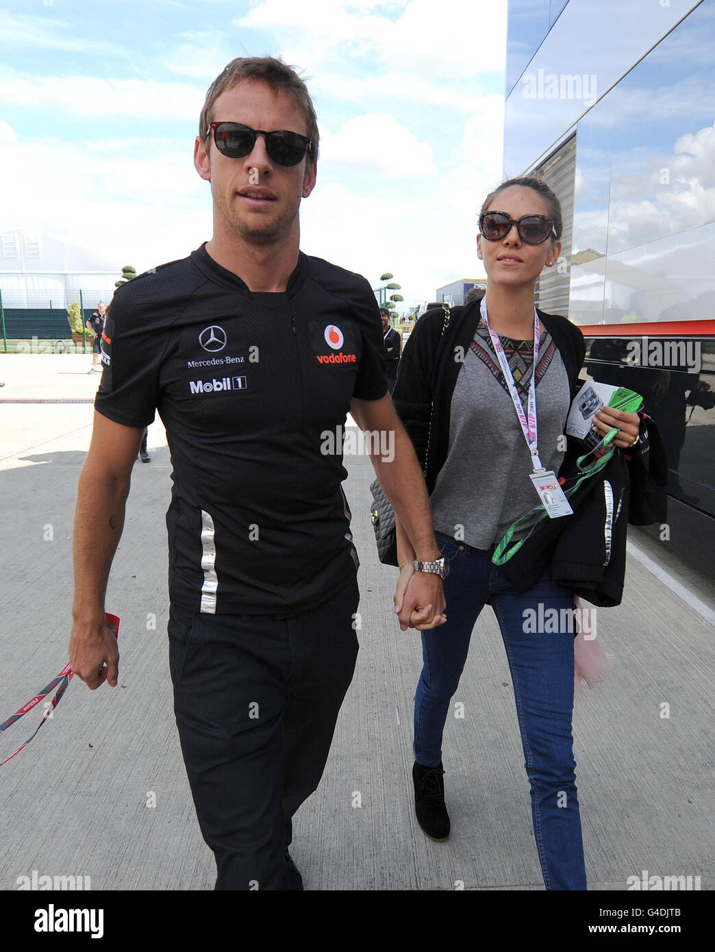 Jenson Button von McLaren Mercedes kommt mit Freundin Jessica Michibata am Fahrerlager-Tag zum British Grand Prix der Formel 1 von Santander auf dem Silverstone Circuit in Northampton in Silverstone an. Stockfoto