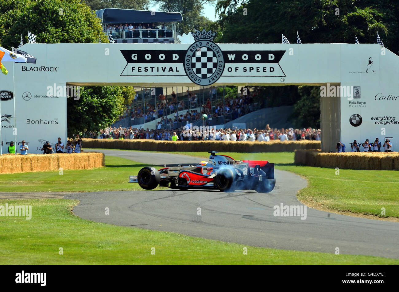 Lewis Hamilton fährt mit einem McLaren MP4/23 F1-Auto und führt Raddrehungen durch, während er am Hill Climb Event beim Goodwood Festival of Speed in Chichester, West Sussex, teilnimmt. Stockfoto