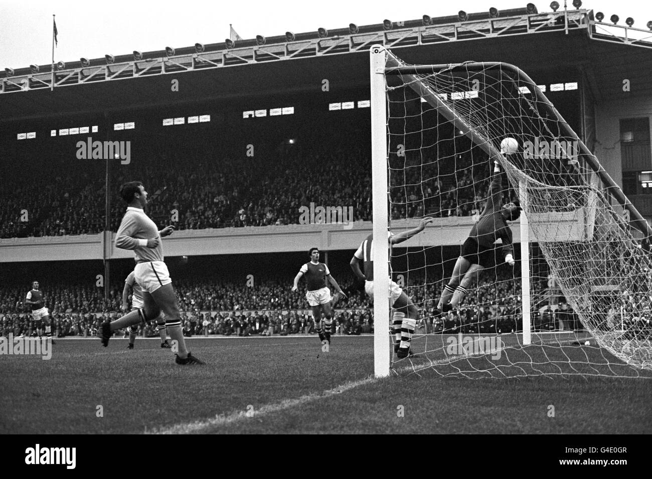 Manchester City Torwart Ken Mulhearn kippt den Ball über die Querlatte, um vor Arsenals Bobby Gould (c) zu retten. David Jenkins von Arsenal (hinter dem Torpfosten) und Glyn Pardoe von Manchester City (l.). Stockfoto